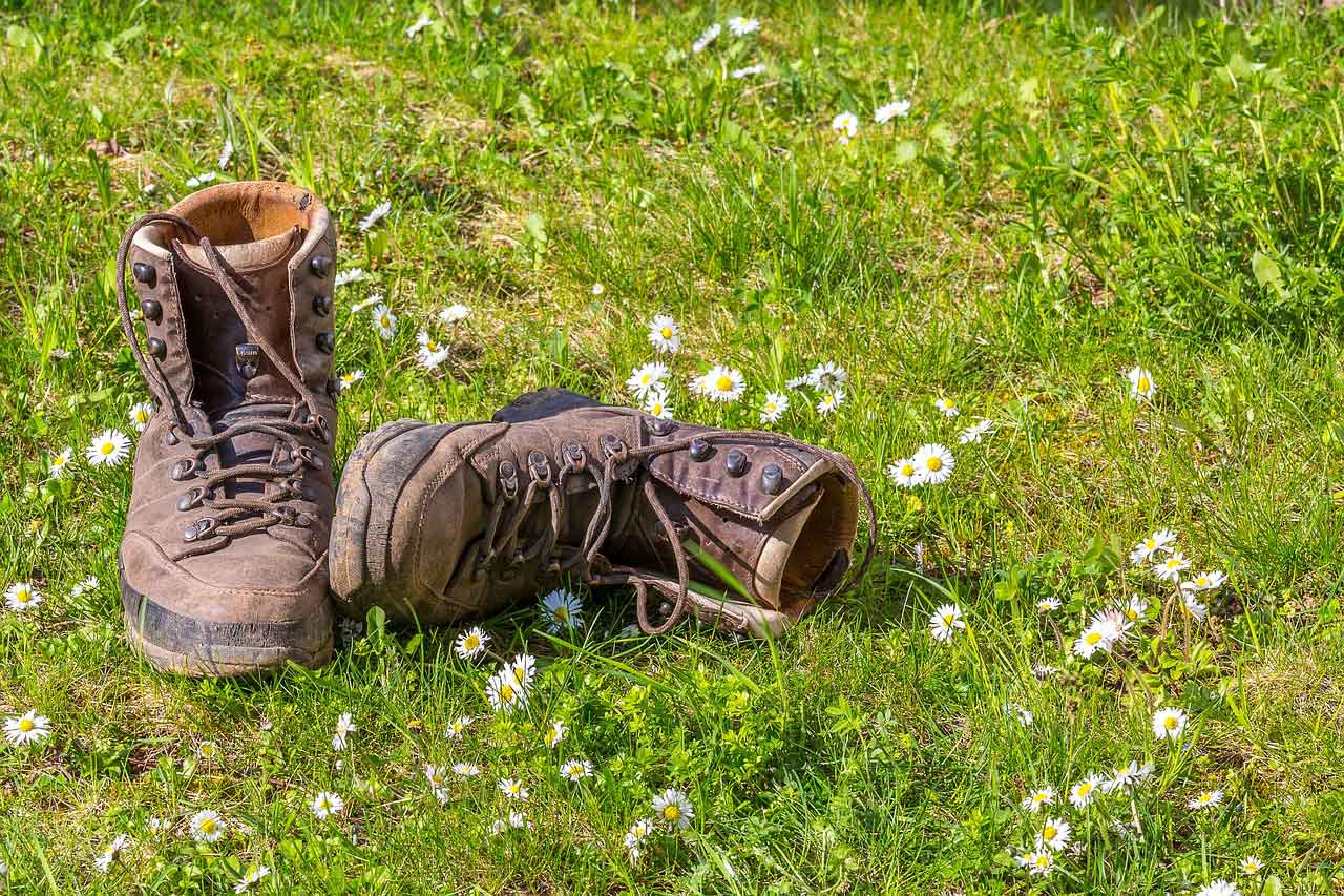 Das Key Visual der Wander-Challenge "Wie weit gehst du?" zieren zwei Wanderschuhe im Gras.